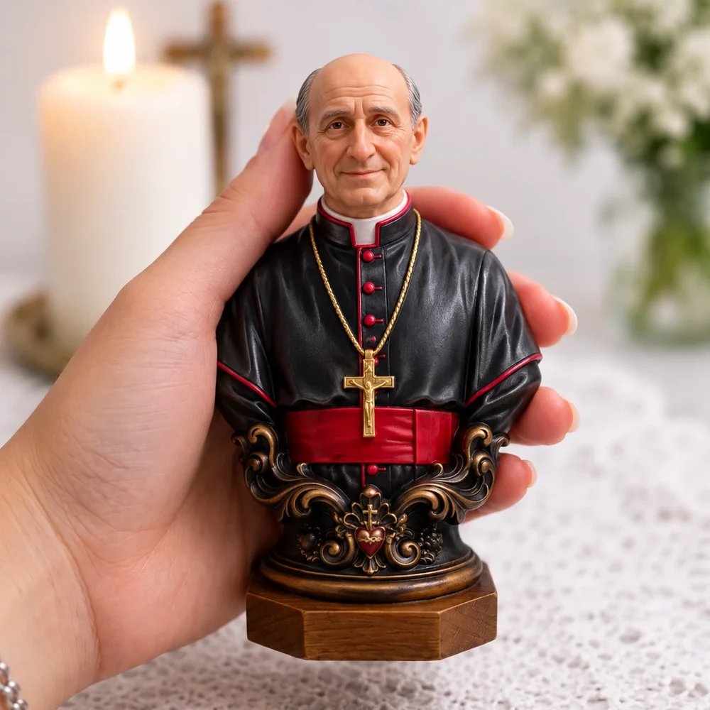 Busto de sacerdote de batina preta com faixa vermelha e crucifixo dourado, segurado na mão