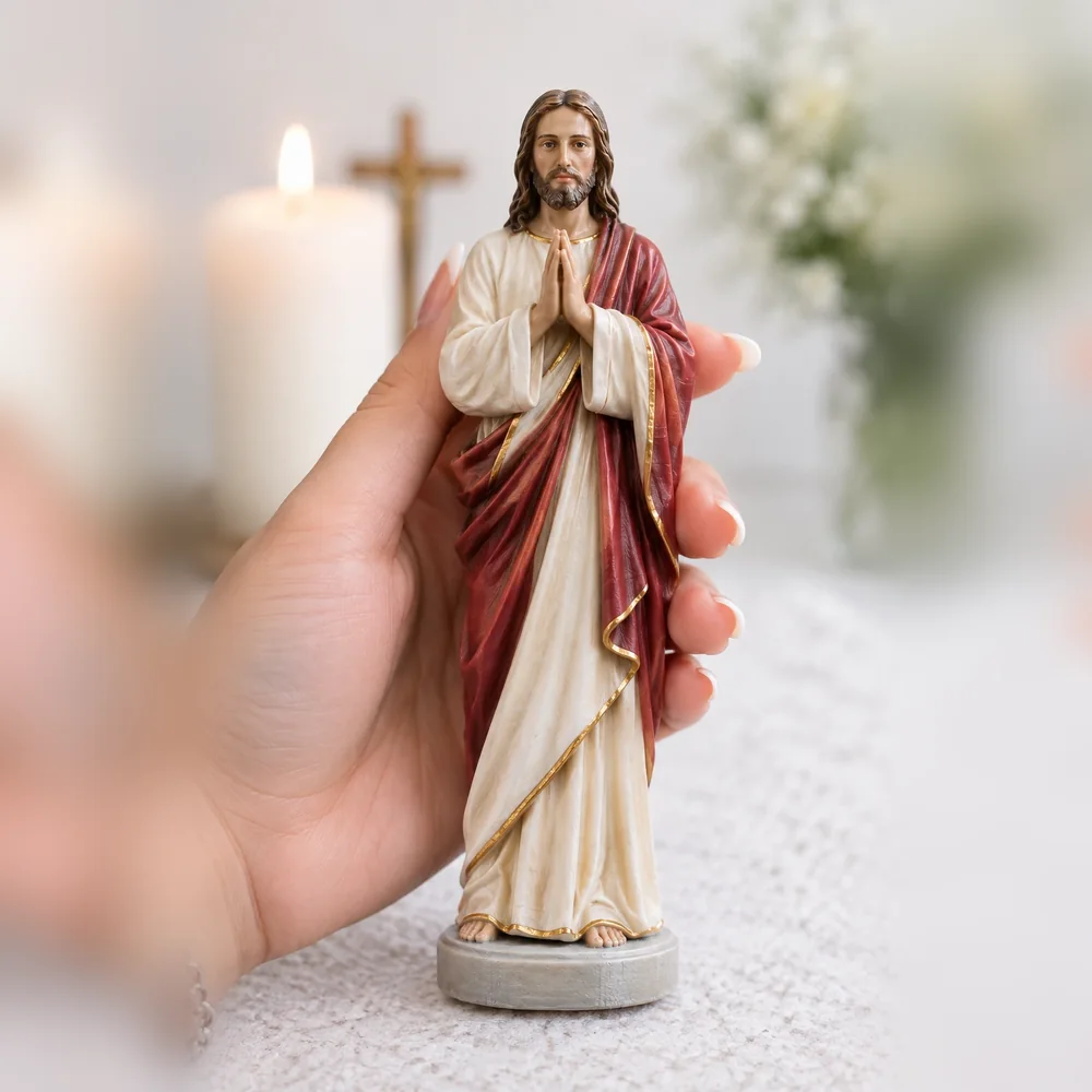 Imagem de Jesus em oração, com manto vermelho, segurada na mão
