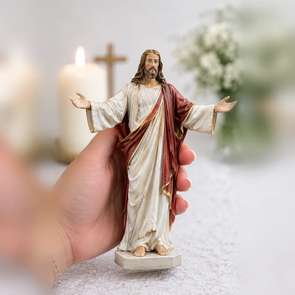 Imagem de Jesus Ressuscitado de braços abertos, com manto vermelho, segurada na mão