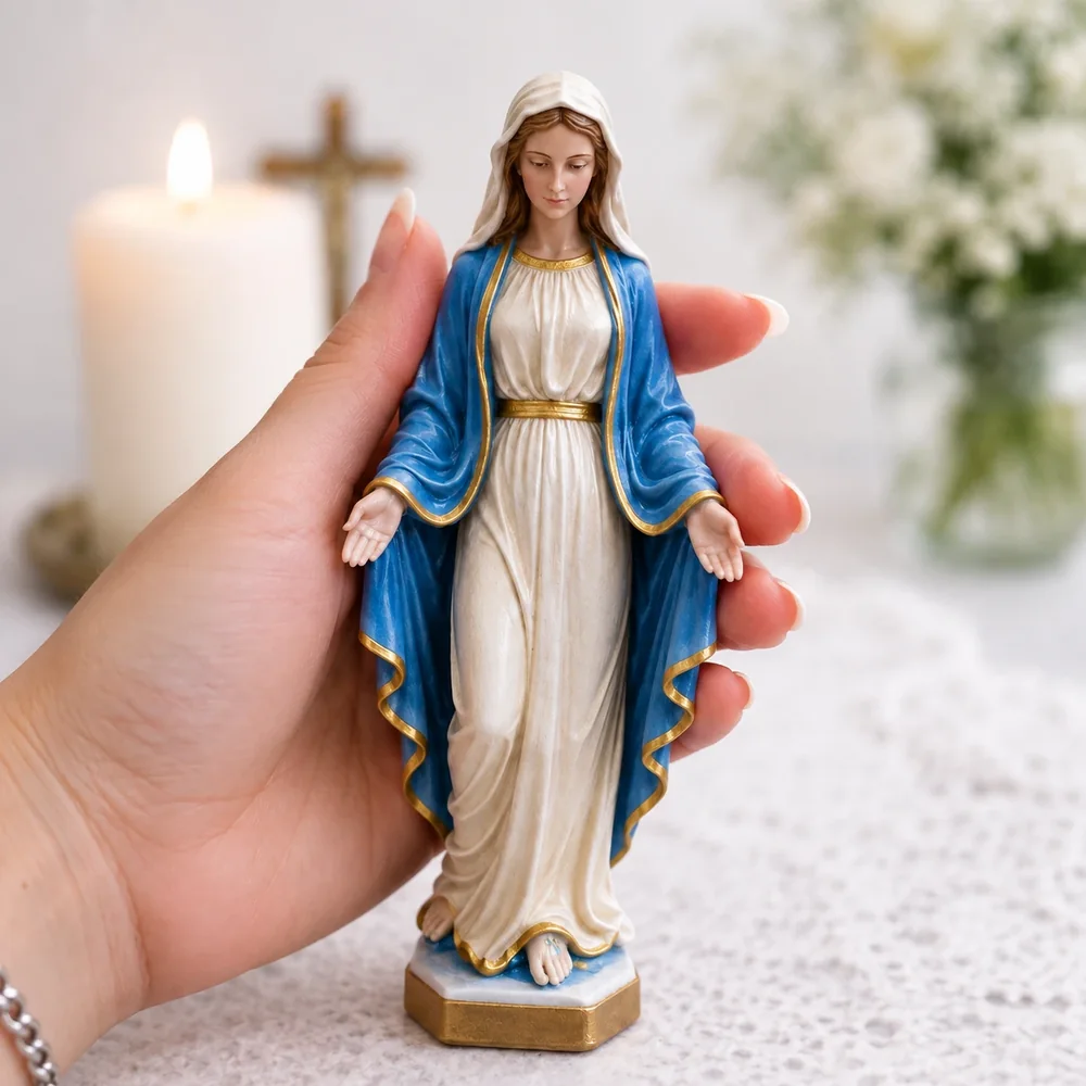 Imagem de Nossa Senhora com manto azul, segurada na palma da mão